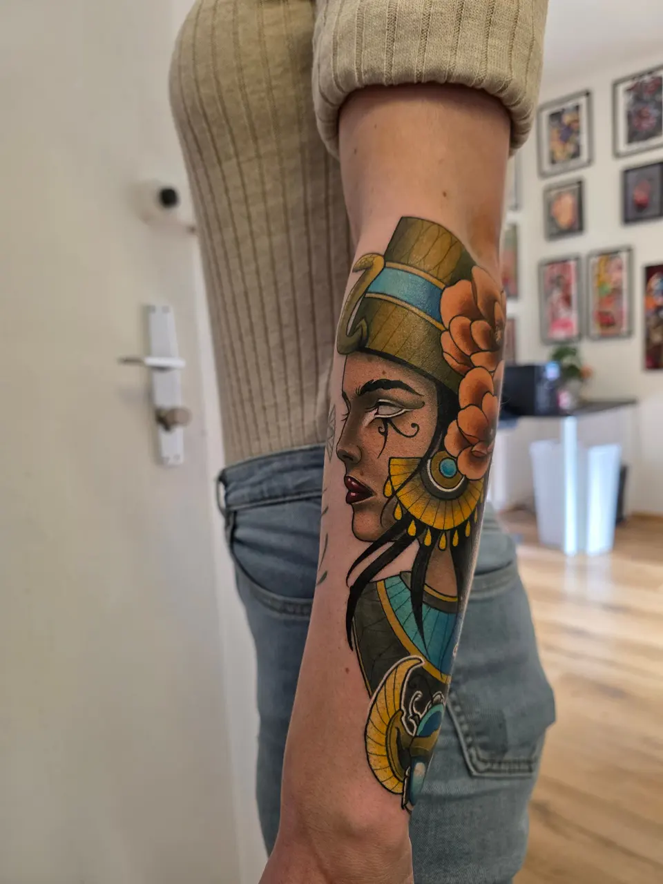Portrait de femme à la coiffe dorée tatoué sur un avant-bras